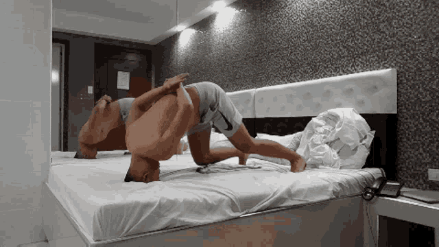 a man is laying on his back on a bed in a room