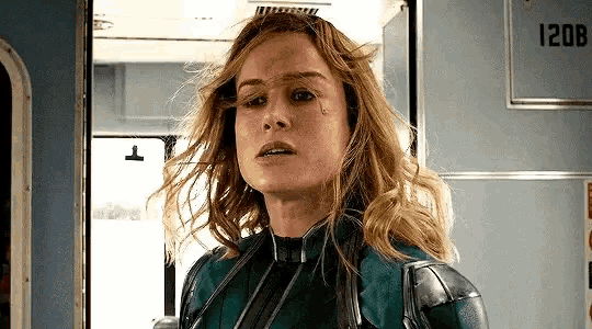 a close up of a woman in a superhero costume standing in a doorway .