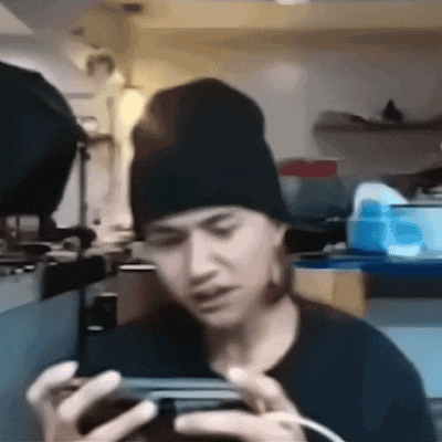 a man wearing a beanie is looking at his phone