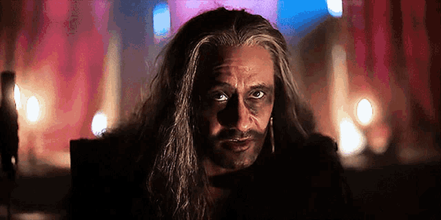 a close up of a man with long hair and a beard