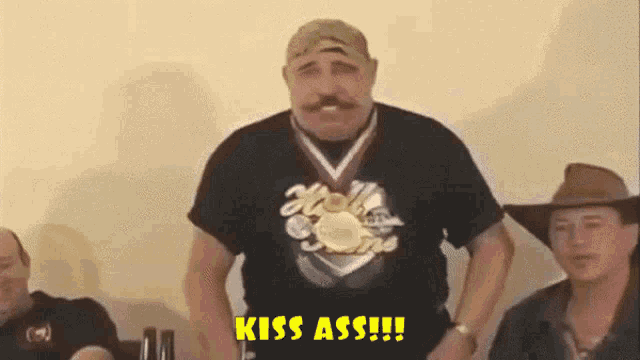 a man is wearing a medal around his neck and says kiss ass
