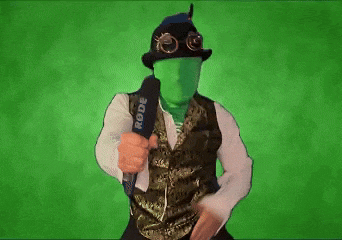 a man with a green face is holding a microphone in front of a green background .
