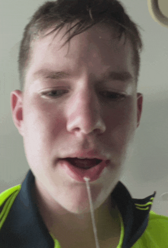 a close up of a young man 's face with his mouth open