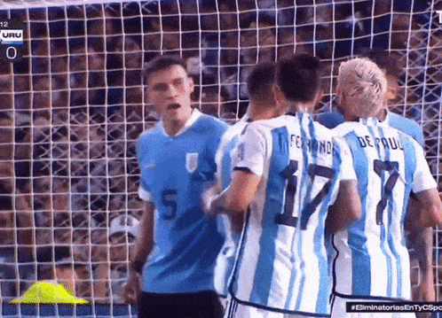 a group of soccer players including fernanda and de paul are huddled together
