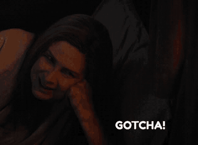 a woman laying on a bed with the word gotcha in the corner