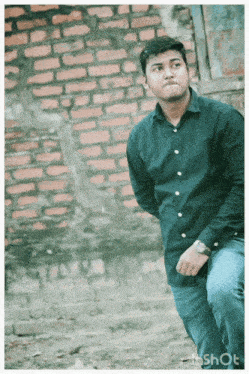 a man in a black shirt stands in front of a brick wall with the word shot on the bottom right