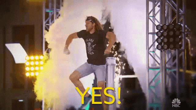 a man in a black shirt with the word island on it is jumping in the air