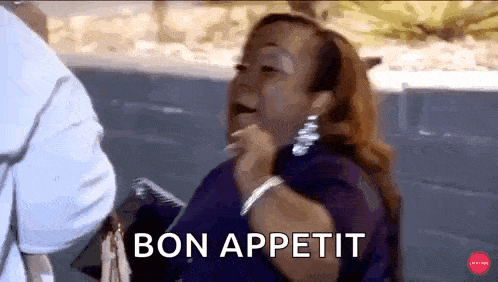 a woman in a purple shirt is saying `` bon appetit '' while talking to another woman .