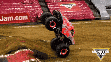 a monster jam truck is doing a trick on the dirt track