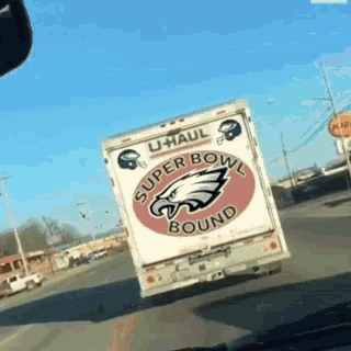 a super bowl bound u-haul truck is driving down a road
