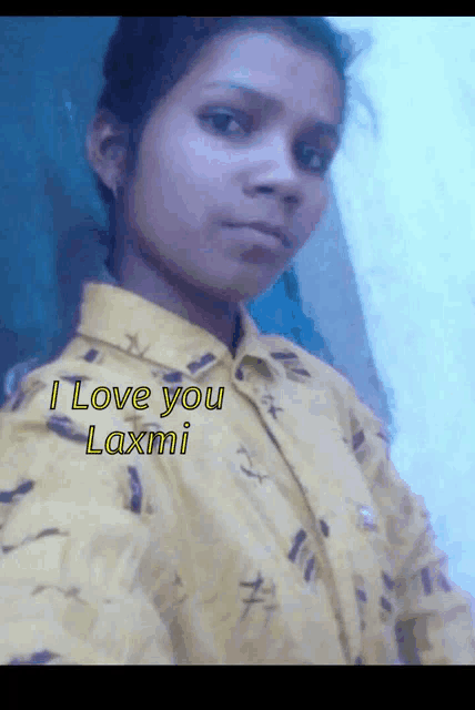 a girl in a yellow shirt with the words " i love you laxmi " on it