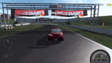 a red car is driving down a race track in front of banners that say doing well