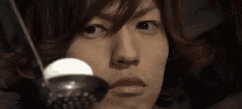 a close up of a person 's face with a spoon in his mouth .