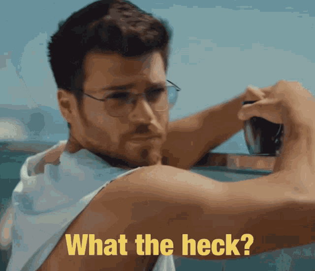 a man wearing glasses and a white tank top with the words what the heck on the bottom