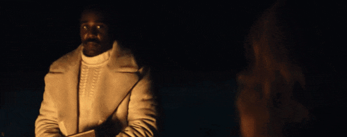 a man with a mustache is wearing a white jacket