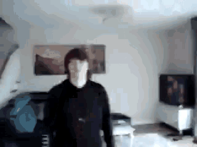 a person is standing in a living room with a painting on the wall .