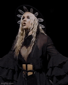 a blonde woman wearing a black hat and a black crop top