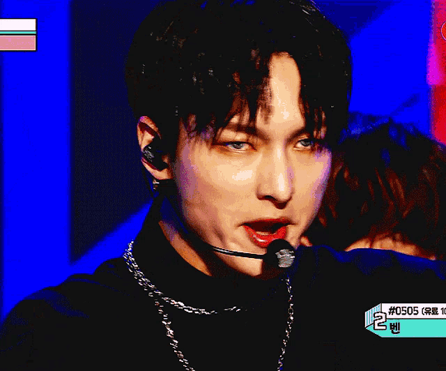 a close up of a person holding a microphone with the number 0505