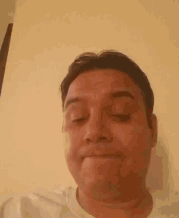 a close up of a man 's face with his eyes closed .