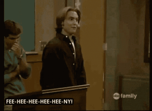 a man is standing in front of a bulletin board with the words fee-hee-hee-hee-nye on it