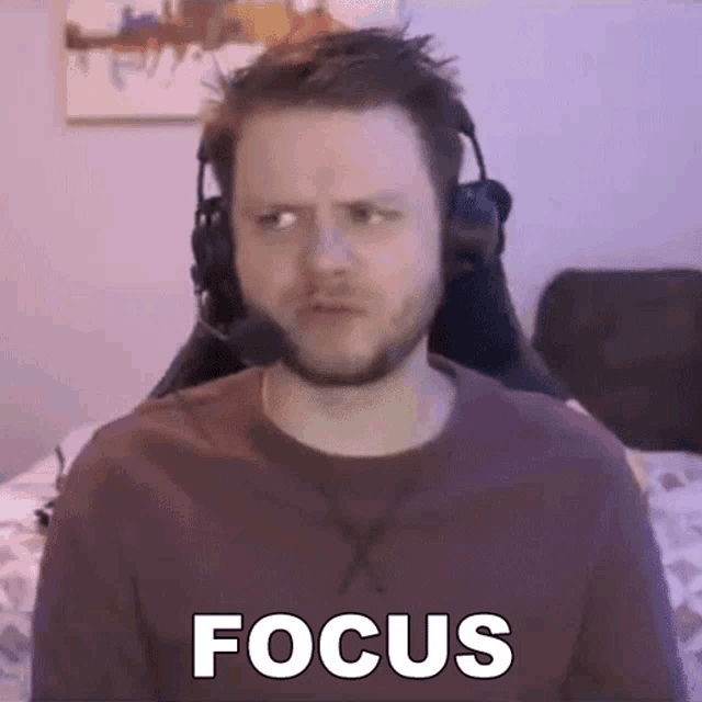 a man with a beard wearing headphones is sitting in a chair and making a funny face .