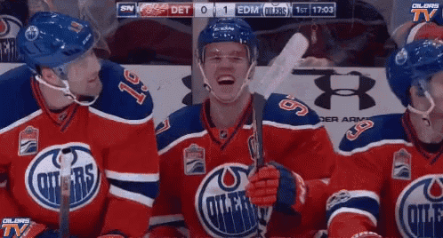 three edmonton oilers hockey players are sitting in the stands