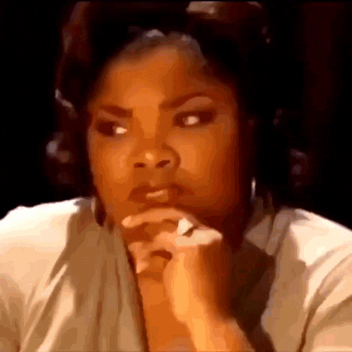 a woman is sitting at a table with her hands on her chin .