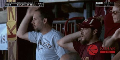 a man wearing a florida state shirt is watching a basketball game