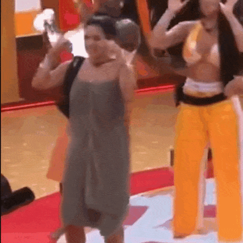 two women are standing next to each other on a red carpet in a room .