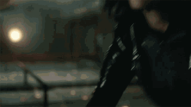 a close up of a person 's arm with a gun in a dark room .