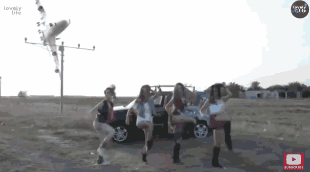 a group of women are dancing in front of a car and a sign that says lovely life on it