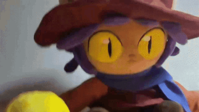 a close up of a stuffed animal with purple hair and yellow eyes