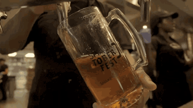 a man pours beer into a glass that says toberfest