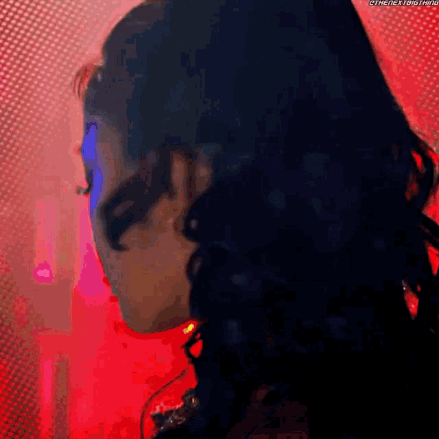a close up of a woman 's face in front of a red background .