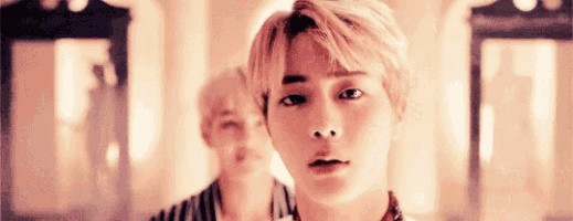 a close up of a young man 's face in a room with a mirror in the background .