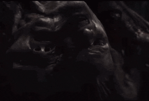 a close up of a person 's face in a dark room .