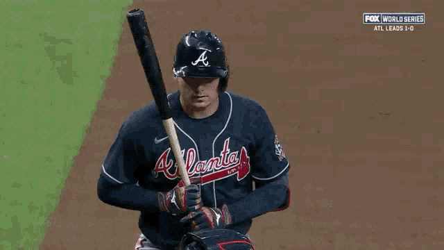 a baseball player is holding a bat while standing on a baseball field .