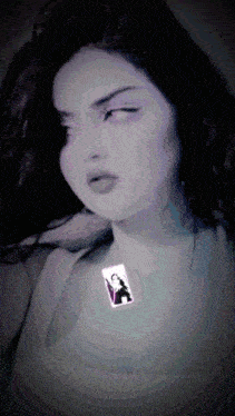 a woman wearing a necklace that has a picture of a woman on it