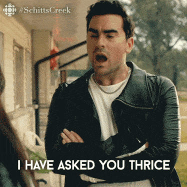 a man in a leather jacket says i have asked you thrice with his arms crossed