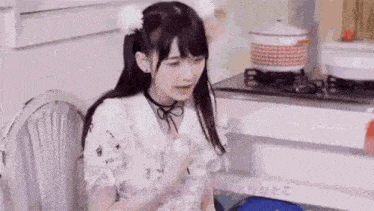 a young girl is sitting in a chair in front of a stove .