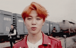 a man with red hair is wearing a red leather jacket and a white shirt .