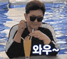 a man wearing sunglasses is drinking a drink through a straw in a swimming pool .