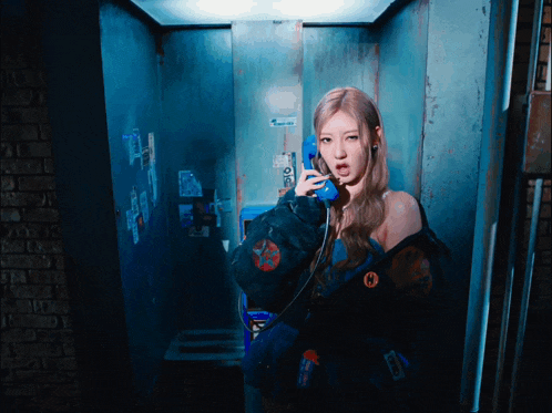a woman is talking on a phone with a sticker on the wall that says ' a ' on it