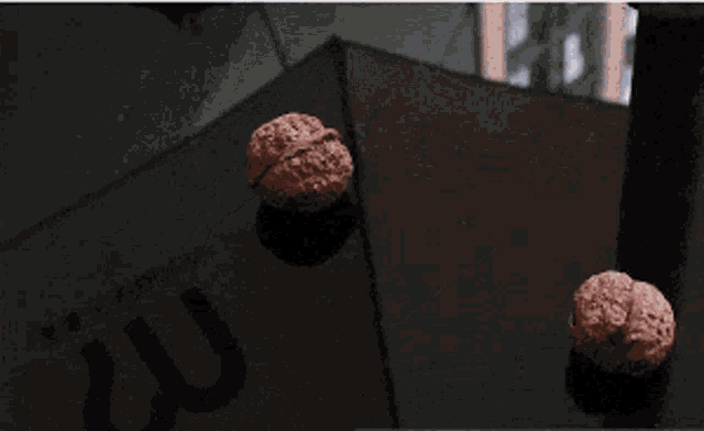 a close up of a person 's hand holding a piece of metal on a table