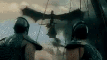 two men are standing in front of a dragon flying through the air .