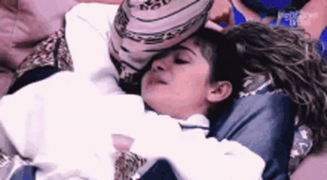 a woman is holding another woman 's head while they are laying on a bed .