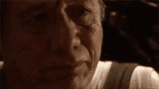 a close up of a man 's face in a dark room in a dark room .