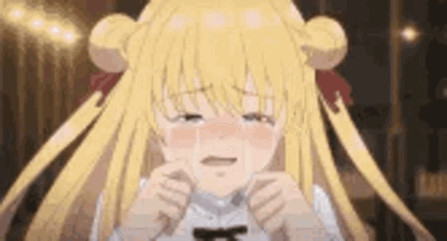 a girl with blonde hair is crying while holding her hands to her face .