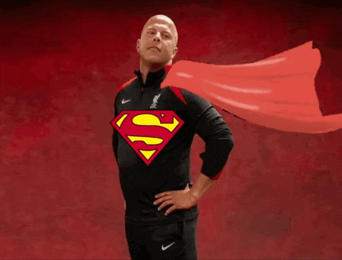 a man wearing a black shirt with a superman logo on the front
