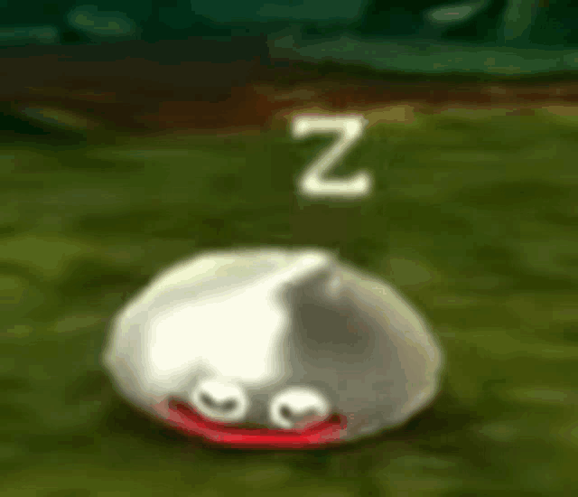 a silver slime with red eyes is sleeping on the grass .